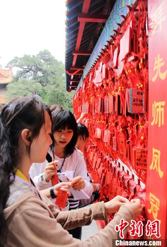 资料图为台湾学生在孔庙大成殿前悬挂许愿牌，祈福自己升学顺利。中华经济报发 李欣 摄